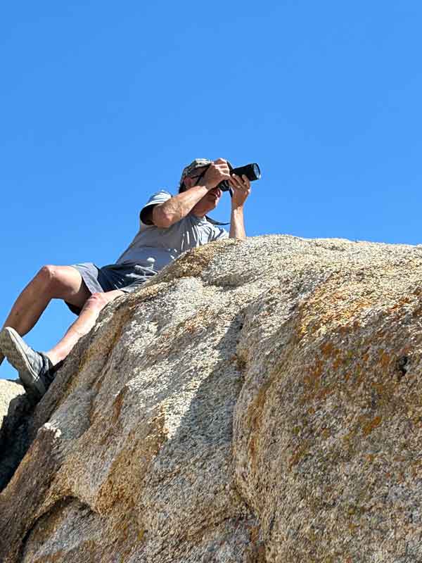 Mike on a rock taking a photo