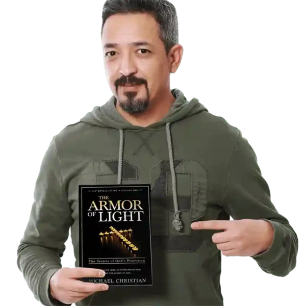 Man wearing a green hoodie pointing to The Armor of Light book